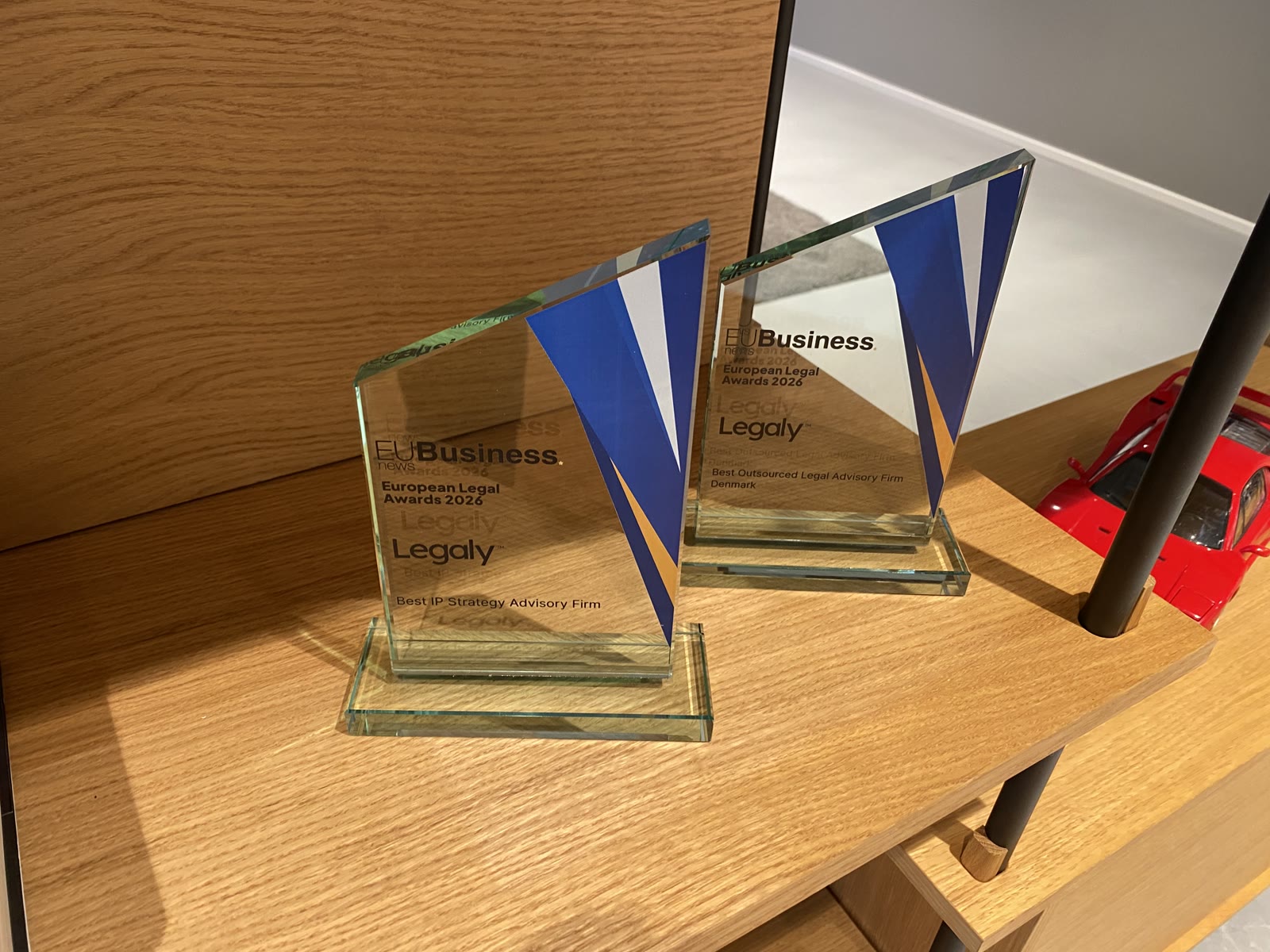 The two European Legal Awards 2026 trophies on the shelf at the Legaly office